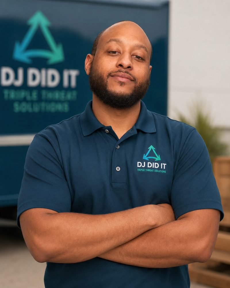 DJ Did It owner standing with arms crossed in branded work shirt
